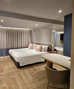 a hotel room with two beds and a table at The Quarter Ladprao by UHG in Bangkok