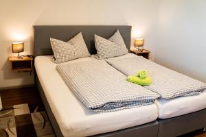 a bed with a green toy sitting on top of it at Gasthaus Stoiber in Buchbach