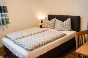 a bed with pillows on it in a room at Gasthaus Stoiber in Buchbach +53 photos
