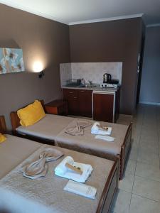 a hotel room with two beds and a kitchen at Hotel Manos in Paralia Katerinis