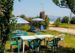 a group of tables and chairs with umbrellas at Eftichia Apartment in Roda