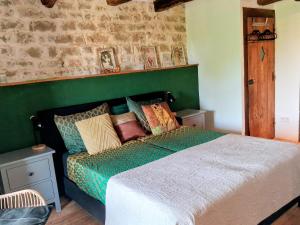 a bedroom with a bed with a green headboard and pillows at Chateau d'Impasse in Laferté-sur-Amance