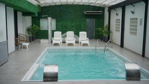 a large swimming pool with chairs and a table at Ker Recoleta Hotel in Buenos Aires