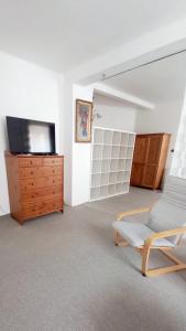 a living room with a tv and a dresser at Apartmány Karlštejn in Karlštejn