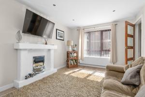 a living room with a fireplace and a flat screen tv at The Nest in Belfast