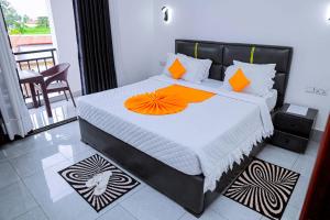 a bedroom with a large bed with orange pillows at Martin Aviator Apartment in Kigali