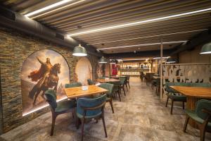 a restaurant with tables and chairs and a painting on the wall at King Gorgasali in Tbilisi City