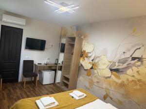 a bedroom with a painting of flowers on the wall at Casa Aurelia in Sibiu