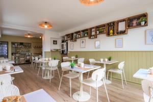 a dining room with tables and chairs in a restaurant at Hôtel La Baïne in Capbreton