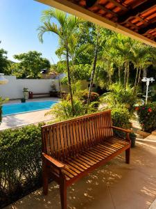 a wooden bench sitting on a patio near a pool at Pousada Alter Villa Suítes in Alter do Chao