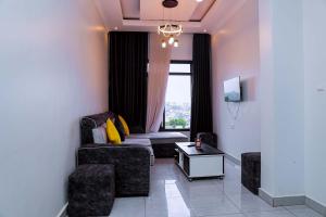 a living room with a couch and a window at Martin Aviator Apartment in Kigali