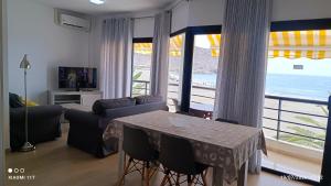 a living room with a table and a view of the ocean at Brisa Mar in Gran Tarajal