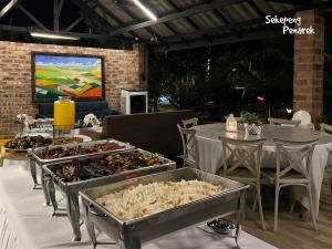 a table with several trays of food on it at Sekepeng Penarek in Kampung Penarik