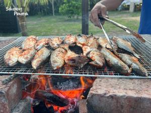 a bunch of sausages and other food on a grill at Sekepeng Penarek in Kampung Penarik +21 photos