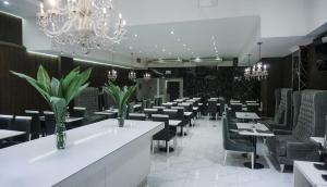 a dining room with tables and chairs and a chandelier at Ker Recoleta Hotel in Buenos Aires