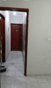a hallway with a door and a tile floor at Quarto econômico e confortável in Hortolândia