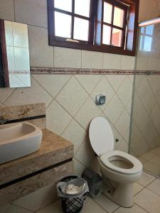 a bathroom with a toilet and a sink at Quarto econômico e confortável in Hortolândia