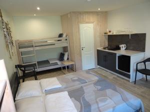 a small room with a bunk bed and a kitchen at Pāvilostas Piparmētras in Pāvilosta +11 photos