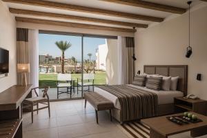 a bedroom with a bed and a balcony with a view at JAZ Elite Riviera in Port Ghalib