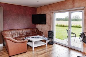 a living room with a leather couch and a table at Sepa puhkemaja in Pärnu