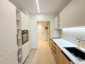 a kitchen with white cabinets and a sink at Cosy place in Pembroke in Pembroke