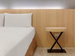 a bed and a small table next to a bed at Guide Hotel Taipei Fuxing North in Taipei +105 photos
