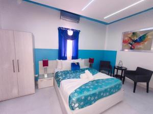a bedroom with a large bed with a blue wall at Hotel La Morada in Santo Domingo