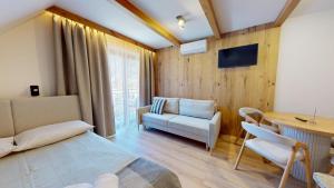 a bedroom with a bed and a table and a chair at Willa Magiera - widok na Trzy Korony in Sromowce Niżne