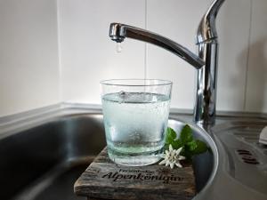 a glass of water is sitting in a sink at Ferienlodge Alpenkönigin Vacation in Stubai Valley in Neustift im Stubaital