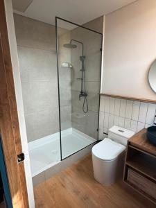 a bathroom with a toilet and a glass shower at Lagoa by Loop in Horizonte +21 photos