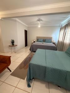 a large bedroom with two beds and a table at Villa das Calliandras in Chapada dos Guimarães +1 photo