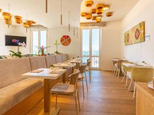 a restaurant with tables and chairs and a couch at Hotel Aristeo in Cagliari