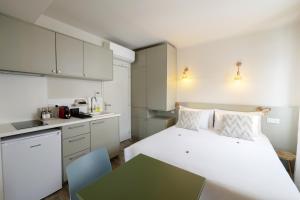 a bedroom with a large white bed and a kitchen at Lo Berge in Saint-Pée-sur-Nivelle +37 photos