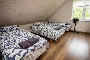 two beds in a room with wooden floors at Sepa puhkemaja in Pärnu
