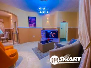 a living room with a couch and a tv at IMSMART Luxury Apartment in Uyo