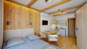 a bedroom with a bed and a table and a kitchen at Willa Magiera - widok na Trzy Korony in Sromowce Niżne