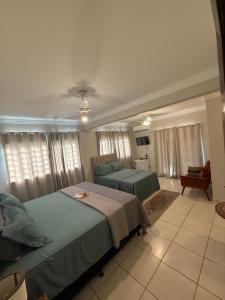 a bedroom with two beds and a couch at Villa das Calliandras in Chapada dos Guimarães