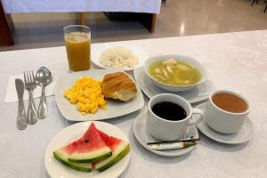 ein Tisch mit Tellern mit Essen und Tassen Kaffee in der Unterkunft Ayenda 1063 Golden in Bogotá
