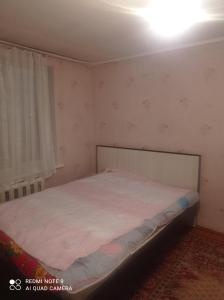 a small bedroom with a bed in a room at Izat in Karakol