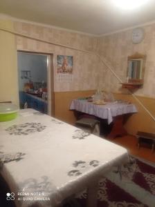 a room with two beds and a table in it at Izat in Karakol