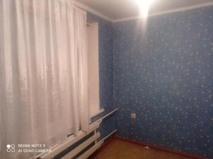 a room with a blue wall with polka dots at Izat in Karakol