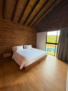 a bedroom with a large bed in a wooden room at Lagoa by Loop in Horizonte