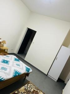 a bedroom with a bed and a white wall at L'évasion-Royale in Thiès