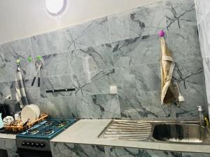a kitchen with a stove and a sink in it at L'évasion-Royale in Thiès +9 photos