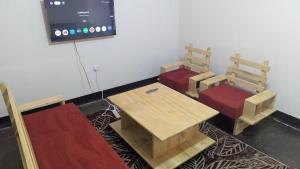 a room with two chairs and a table and a tv at CJ Apartments in Kapchorwa