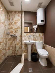 ein Badezimmer mit Toilette, Waschbecken und Dusche in der Unterkunft Skypiea Hotel in Yerevan