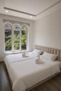 ein Schlafzimmer mit zwei Betten und zwei Fenstern in der Unterkunft Skypiea Hotel in Yerevan
