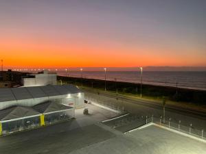 a sunset over a building with the ocean in the background at Pousada Brisa dos Mares Macaé in Macaé