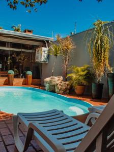a large swimming pool with a bench and plants at Pousada Nanai in Foz do Iguaçu +42 photos