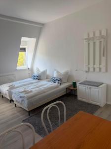 a white bedroom with a bed and a window at Am Goethe Bogen in Zeuthen